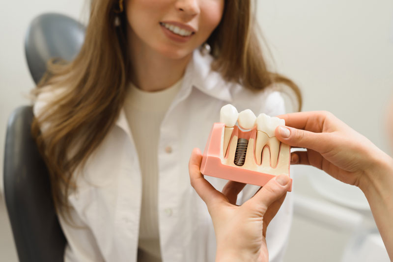 Dental Patient Getting Shown A Dental Implant Model During Her Consultation in Bloomington, MN